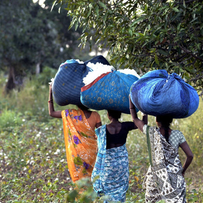Close Up Of Women Carrying Bundles Of Fairtrade Certified, Organic Cotton | Dip & Doze